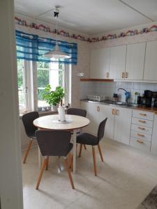 a kitchen with a table and chairs with a plant on it at Lägenhet in Köpingsvik