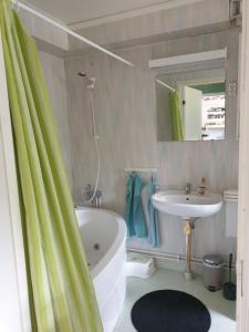 a bathroom with a white tub and a sink at Lägenhet in Köpingsvik
