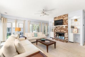 a living room with a white couch and a fireplace at Madelyn's Oceanview in Tybee Island