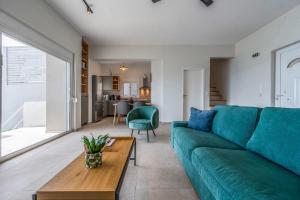 a living room with a green couch and a table at East of Preveli Seafront Villas by TheCreteEscape in Kerames