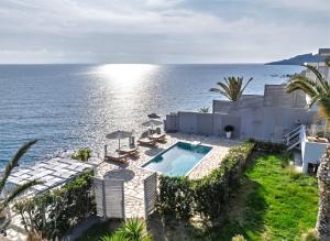 an aerial view of a house with a swimming pool and the ocean at East of Preveli Seafront Villas by TheCreteEscape in Kerames