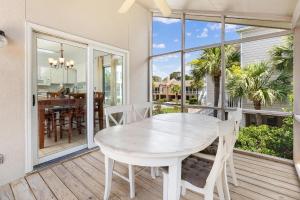 a dining room with a table and chairs on a balcony at Madelyn's Oceanview in Tybee Island