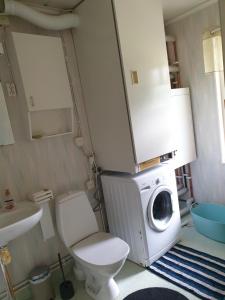 a bathroom with a washing machine and a toilet at Lägenhet in Köpingsvik
