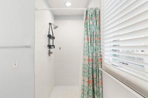 a shower with a floral shower curtain in a bathroom at Madelyn's Oceanview in Tybee Island +27 photos