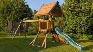 a wooden playset with a slide and a tower at Stor älg in Dalskog
