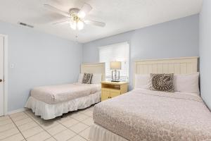 a bedroom with two beds and a ceiling fan at Madelyn's Oceanview in Tybee Island