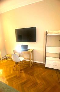 a living room with a television and a desk with a laptop at Iconic Obelisco Studio in Buenos Aires