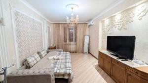 a living room with a couch and a flat screen tv at Аэропорт Комфорт in Chişinău