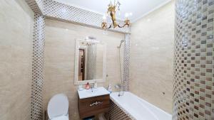 a bathroom with a tub and a sink and a toilet at Аэропорт Комфорт in Chişinău