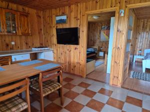 a kitchen with a table and a tv in a room at Dom pod lipą in Łeba