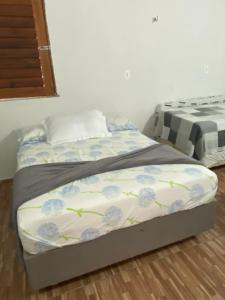 a bedroom with a bed with blue flowers on it at Suíte GUARAMIRANGA no Sítio in Guaramiranga