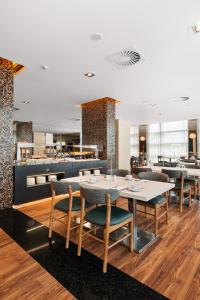 a dining room with tables and chairs in a restaurant at Axis Porto Business & Spa Hotel in Porto
