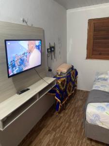 a room with a tv on a counter with a bed at Suíte GUARAMIRANGA no Sítio in Guaramiranga