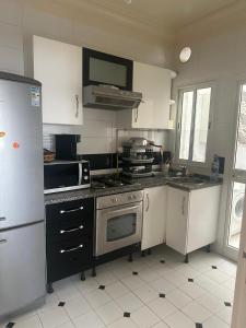 a kitchen with a stove and a refrigerator at Appartement Sousse in Hammam Sousse