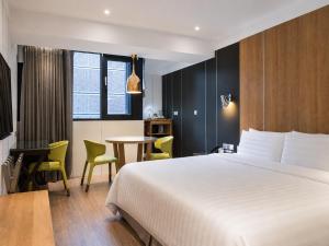 a hotel room with a bed and a table at Hotel Relax II in Taipei