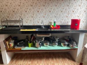 a kitchen counter with a sink and some pots and pans at Suíte GUARAMIRANGA no Sítio in Guaramiranga