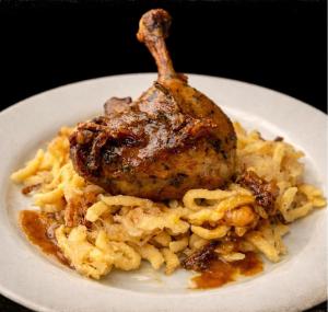 Ein Teller mit Essen, darunter Hühnchen auf Nudeln. in der Unterkunft Amálka u Řípu in Straškov