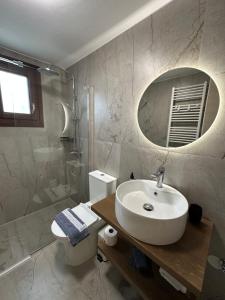 a bathroom with a sink and a toilet and a mirror at Pelion Roots in Zagora