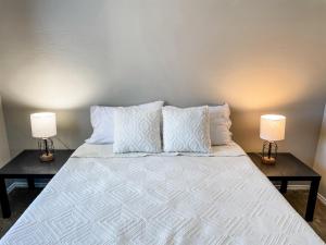 a large bed with two lamps on two tables at 10 Min to Downtown - Pet-friendly, TV with Parking in Robstown