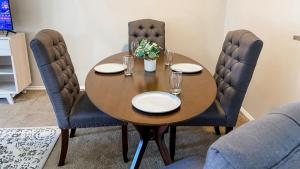 a wooden table with plates and glasses on top of it at 10 Min to Downtown - Pet-friendly, TV with Parking in Robstown