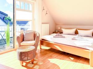 a bedroom with a bed and a chair and a window at Kinnekulle 1 in Groß Kirr