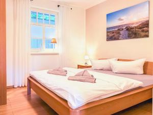 a bedroom with a large white bed with a window at Kinnekulle 1 in Groß Kirr