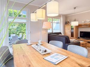 a living room and dining room with a wooden table at Kinnekulle 1 in Groß Kirr +14 photos