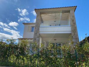 a tall white house with a large pillar at RH1 and RH2 - PuntoCasaBudoni in Budoni