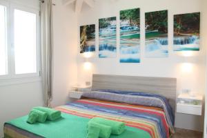 a bedroom with two beds and paintings on the wall at RH1 and RH2 - PuntoCasaBudoni in Budoni