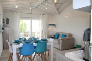 a dining room with a table and blue chairs at RH1 and RH2 - PuntoCasaBudoni in Budoni