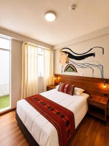 a bedroom with a large bed and a painting on the wall at Cusco - Perú "Hotel Boutique Qorikallpa" The true essence of inka culture in Cusco +68 photos