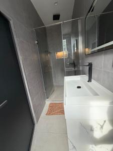 a bathroom with a white sink and a shower at Serene Keys Homes in Otinshi