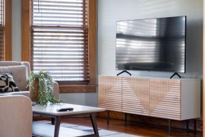 a living room with a flat screen tv on a wall at Robin's Egg, Private Downtown, Pet-Friendly Gem in Columbus