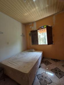 a small bedroom with a bed and a window at Casa da Tia in Salvaterra