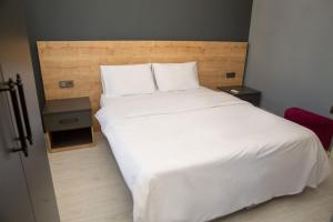 a bed with white sheets and pillows in a bedroom at Eylül Homes in Trabzon +13 photos