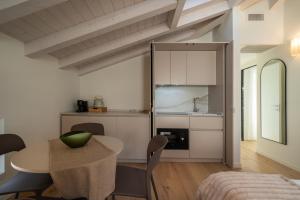a kitchen and dining room with a table and a dining room at Flowers Liberty Suites in Brescia +11 photos