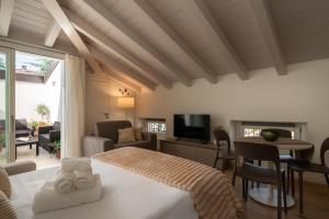 a bedroom with a bed and a living room at Flowers Liberty Suites in Brescia