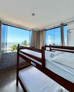 a bedroom with two bunk beds and a view of the ocean at Maraga Beach Hostel in Maragogi