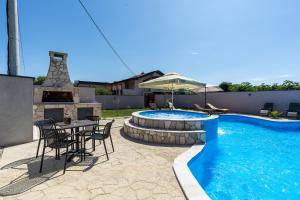 a patio with a table and chairs next to a swimming pool at Villa Bali Oasis Grand Wellness in Stolac