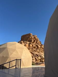 a white dome tent with a mountain in the background at Rehana rum luxury camp in Wadi Rum