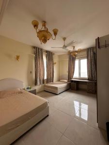 a bedroom with a bed and a chandelier at شقة كبيرة مؤثثة بالكامل in Salalah