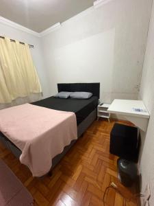 a small room with a bed and a desk at Pousada Dois Irmãos in Uberaba +22 photos