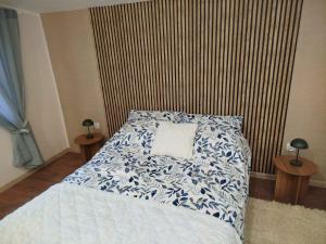 a bedroom with a bed with a blue and white comforter at Apartamenty nad Brdą in Zapędowo