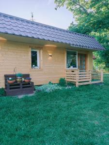 a small yellow house with a porch at Apartamenty nad Brdą in Zapędowo