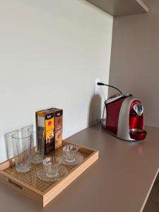 a tray with glasses and a tea kettle on a counter at Apartamento 313 Bobz Concept in Cajueiro