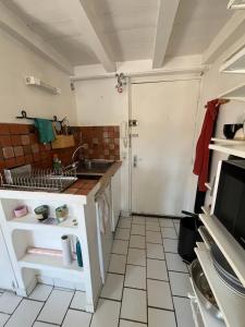 a small kitchen with a sink and a door at Studio au coeur de Aix in Aix-en-Provence