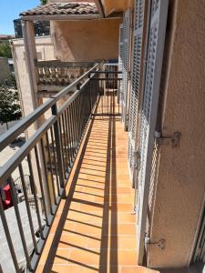 a balcony of a building with its shadows on the ground at Studio au coeur de Aix in Aix-en-Provence