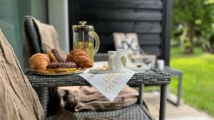 a table with a plate of pastries and a cup of coffee at Gold Luxury Romantic SPA Suite Private Jacuzzi & Sauna in Kołobrzeg +16 photos