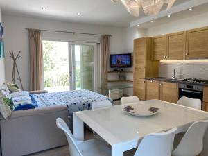 a kitchen and living room with a table and a bed at RH1 and RH2 - PuntoCasaBudoni in Budoni