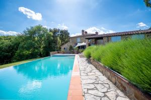 a swimming pool in front of a house at Private Tuscan Villa with Infinity Pool & Views in Vagliagli